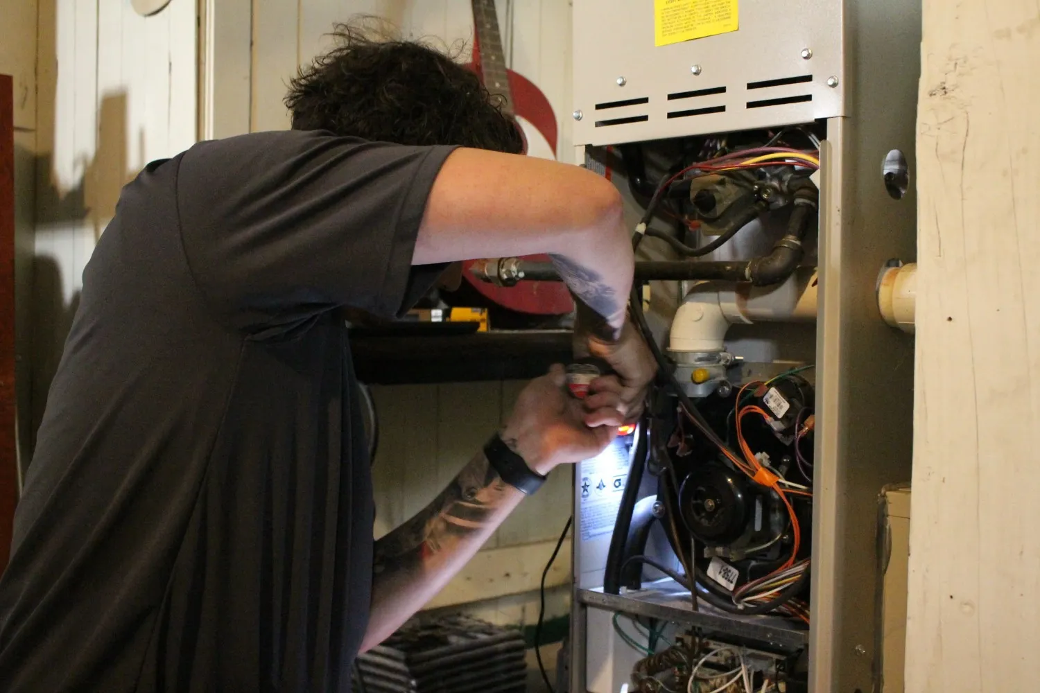 Technician working on an open residential furnace