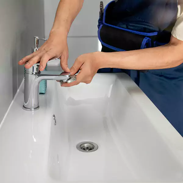 Plumber working on a bathroom faucet